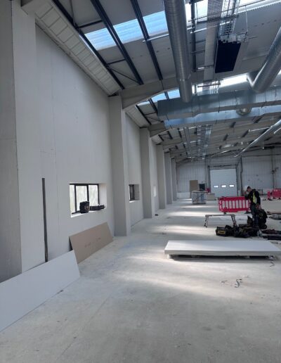 Metal stud drylining partition being installed along the length of a commercial warehouse