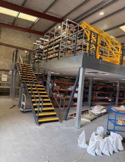 Mezzanine floor with steel staircase and yellow safety railings