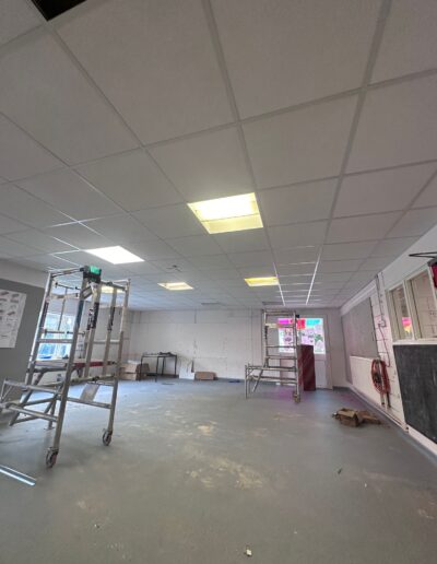 Suspended lay-in grid ceiling with integrated panel lighting